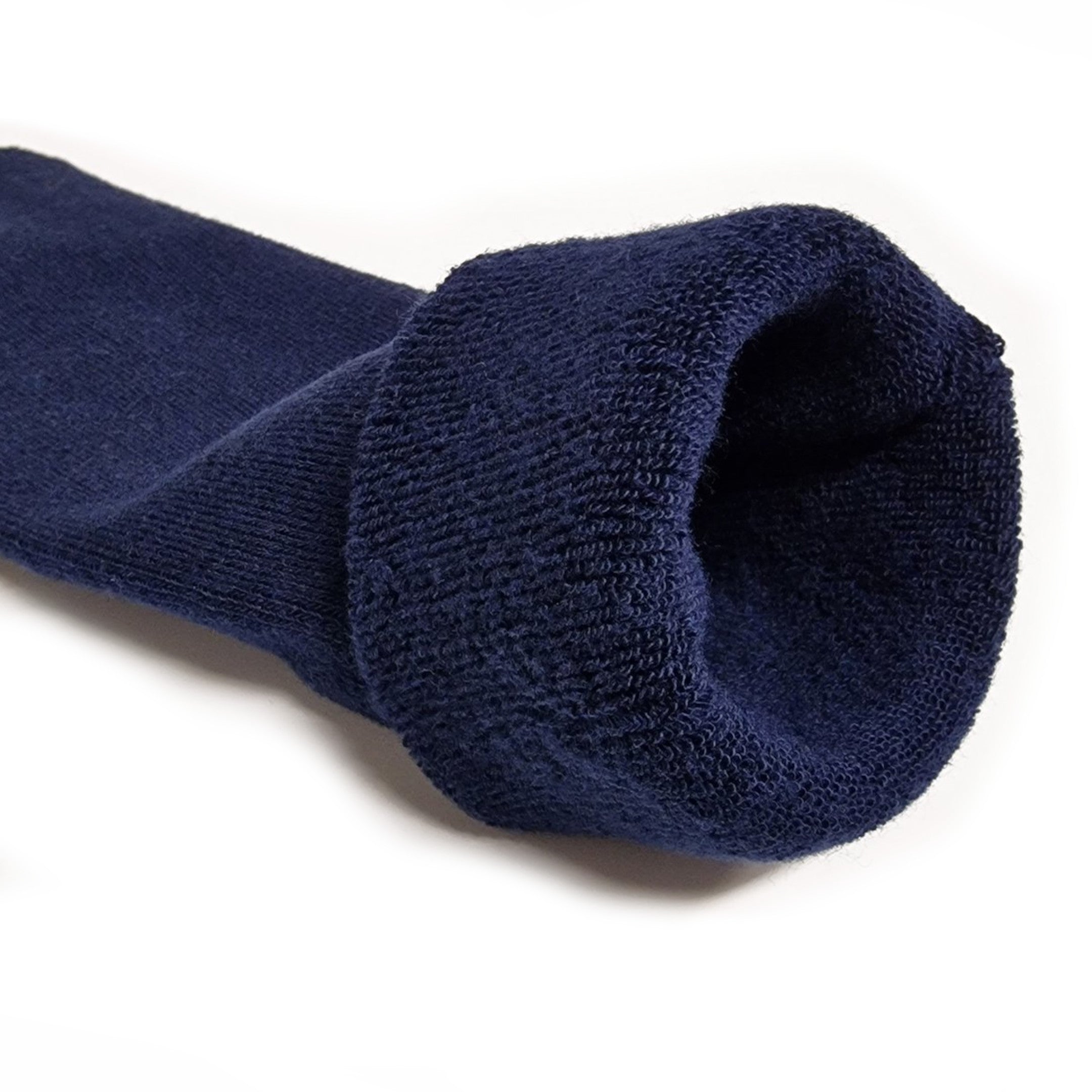 Detailfoto van een blauwe Calzera antislip sok met de boord twee keer naar buiten gevouwen, waardoor de zachte badstof binnenkant zichtbaar is, ideaal voor comfort en stijl.