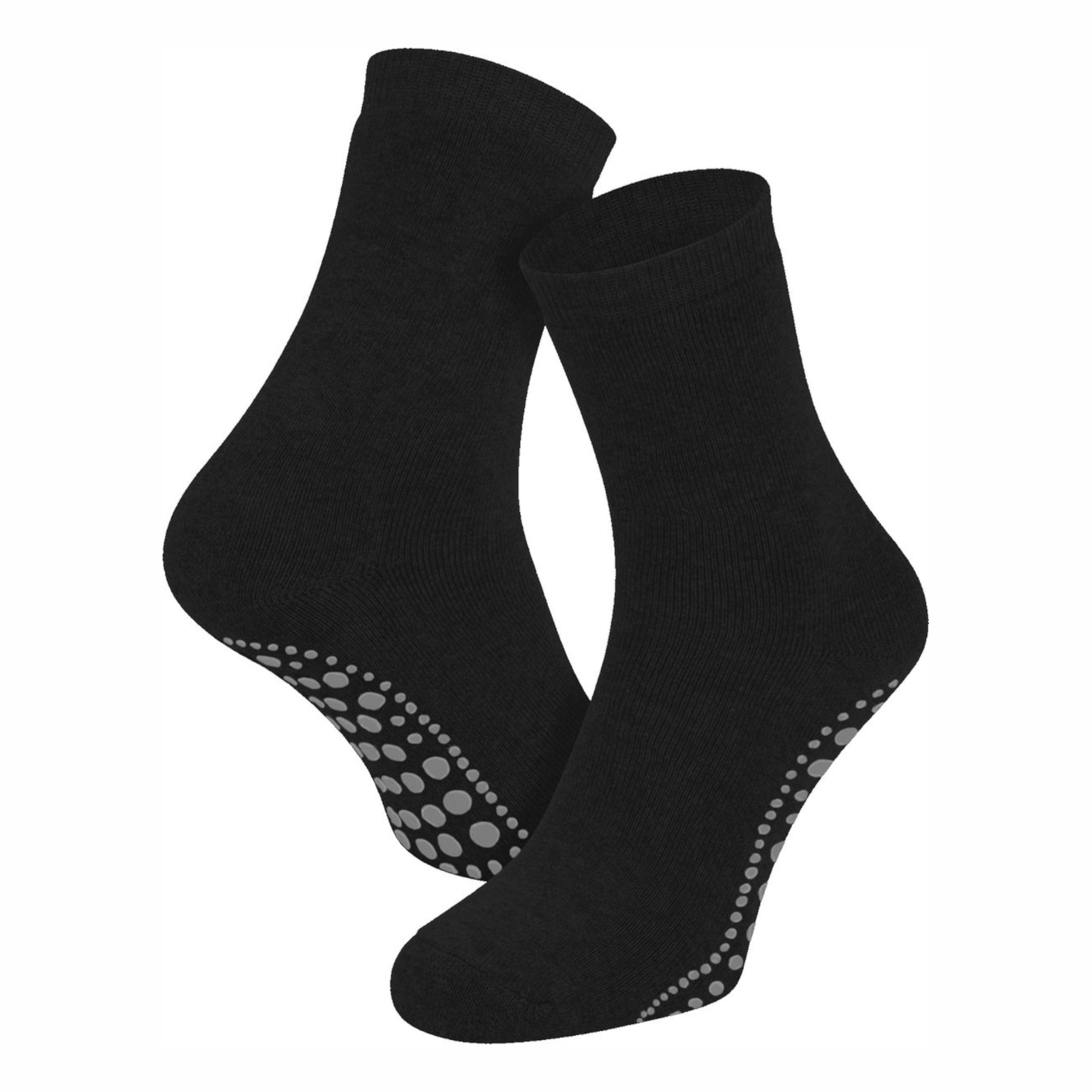 Twee zwarte Calzera antislip sokken in gedragen vorm op een witte achtergrond; één sok toont de achterkant en de andere sok toont de voorkant, perfect voor gebruik binnenshuis.